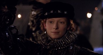 Movie still from “Orlando” (1992), directed by Sally Potter – A man wearing a black hat and a black jacket; Close Up shot, Over the shoulder angle