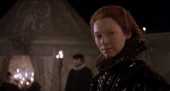Movie still from “Orlando” (1992), directed by Sally Potter – A woman with red hair wearing a black dress; Close Up shot, Over the shoulder angle