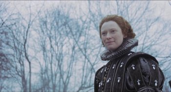 Movie still from “Orlando” (1992), directed by Sally Potter – A woman in a black jacket standing in front of a tree; Close Up shot, Low angle