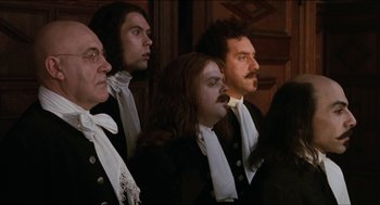 Movie still from “Orlando” (1992), directed by Sally Potter – A group of men in black suits and white ties; Medium shot, Low angle