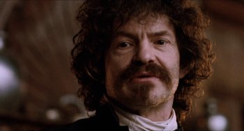 Movie still from “Orlando” (1992), directed by Sally Potter – A person wearing a suit and tie; Close Up shot, Low angle