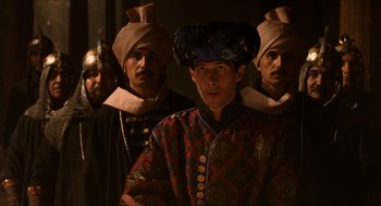 Movie still from “Orlando” (1992), directed by Sally Potter – A group of men standing next to each other wearing hats; Medium shot, Over the shoulder angle