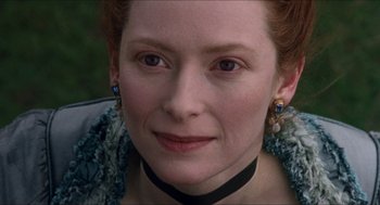 Movie still from “Orlando” (1992), directed by Sally Potter – A person wearing a necklace; Close Up shot, Over the shoulder angle