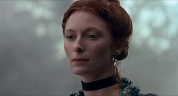 Movie still from “Orlando” (1992), directed by Sally Potter – A person wearing a necklace; Close Up shot, Low angle