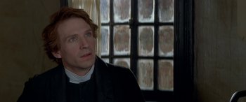 Movie still from “Oscar and Lucinda” (1997), directed by Gillian Armstrong – A person wearing a priest's outfit; Close Up shot, Over the shoulder angle