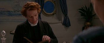 Movie still from “Oscar and Lucinda” (1997), directed by Gillian Armstrong – A man is reading a book in front of a window; Medium shot, High angle