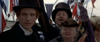 Movie still from “Oscar and Lucinda” (1997), directed by Gillian Armstrong – A group of people wearing hats on top of a bus; Close Up shot, Over the shoulder angle