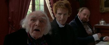 Movie still from “Oscar and Lucinda” (1997), directed by Gillian Armstrong – A man standing next to an older man; Close Up shot, Over the shoulder angle
