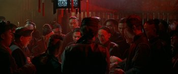 Movie still from “Oscar and Lucinda” (1997), directed by Gillian Armstrong – A group of people gathered in a dark room; Medium shot, High angle