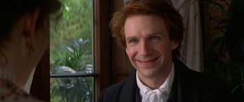 Movie still from “Oscar and Lucinda” (1997), directed by Gillian Armstrong – A person wearing a suit and smiling; Close Up shot, Over the shoulder angle