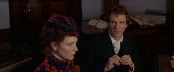 Movie still from “Oscar and Lucinda” (1997), directed by Gillian Armstrong – A man and a woman sitting next to each other; Close Up shot, High angle