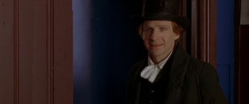 Movie still from “Oscar and Lucinda” (1997), directed by Gillian Armstrong – A man wearing a top hat and a bow tie; Close Up shot, Over the shoulder angle