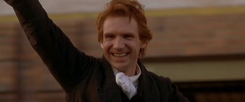 Movie still from “Oscar and Lucinda” (1997), directed by Gillian Armstrong – A person with red hair smiling; Close Up shot, Low angle