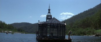 Movie still from “Oscar and Lucinda” (1997), directed by Gillian Armstrong – Two men stand on a boat in the middle of a lake; Extreme Wide shot, Low angle