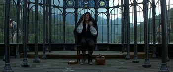 Movie still from “Oscar and Lucinda” (1997), directed by Gillian Armstrong – A man sitting in a chair in front of stained glass windows; Wide shot, Low angle