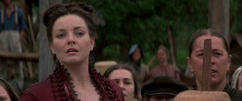 Movie still from “Oscar and Lucinda” (1997), directed by Gillian Armstrong – A woman standing in front of a group of people; Close Up shot, Over the shoulder angle