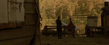 Movie still from “Oscar and Lucinda” (1997), directed by Gillian Armstrong – A man and a woman standing next to each other on top of a wooden fence; Extreme Wide shot, Over the shoulder angle