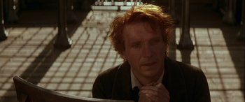 Movie still from “Oscar and Lucinda” (1997), directed by Gillian Armstrong – A person sitting down with his hands clasped; Close Up shot, Over the shoulder angle