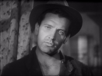 Movie still from “Obsession” (1943), directed by Luchino Visconti – Black and white photograph of a man wearing a hat; Close Up shot, Over the shoulder angle