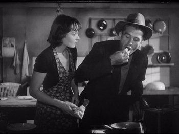 Movie still from “Obsession” (1943), directed by Luchino Visconti – A man and a woman in a kitchen; Medium shot, Low angle