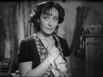 Movie still from “Obsession” (1943), directed by Luchino Visconti – A woman holding a towel while standing in a room; Close Up shot, High angle