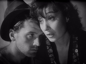 Movie still from “Obsession” (1943), directed by Luchino Visconti – A man and a woman are looking at the camera; Close Up shot, High angle