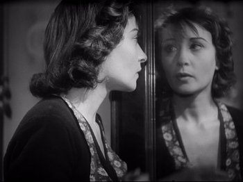 Movie still from “Obsession” (1943), directed by Luchino Visconti – A black and white photo of a woman looking in a mirror; Close Up shot, Over the shoulder angle