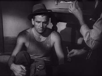 Movie still from “Obsession” (1943), directed by Luchino Visconti – An old photo of a man with a hat on; Medium shot, Over the shoulder angle