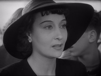 Movie still from “Obsession” (1943), directed by Luchino Visconti – A woman wearing a black hat and a black dress; Close Up shot, Over the shoulder angle
