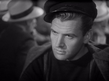Movie still from “Obsession” (1943), directed by Luchino Visconti – A black and white photo of a man wearing a hat; Close Up shot, High angle