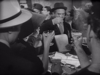 Movie still from “Obsession” (1943), directed by Luchino Visconti – A black and white photo of a group of people at a party; Medium shot, High angle