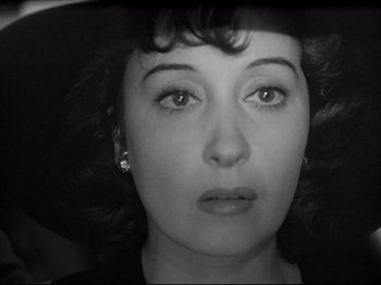 Movie still from “Obsession” (1943), directed by Luchino Visconti – A person wearing a hat and looking at the camera; Close Up shot, High angle