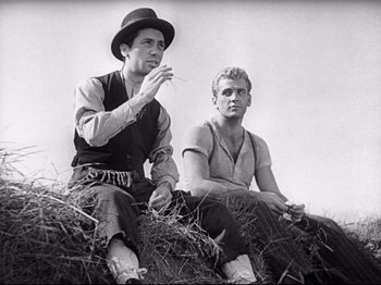 Movie still from “Obsession” (1943), directed by Luchino Visconti – Two men sitting on top of a pile of hay; Medium shot, Low angle