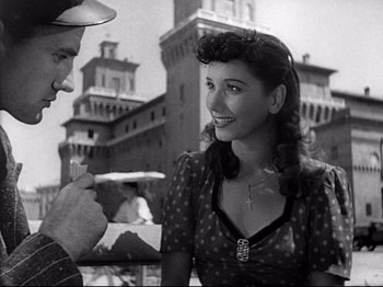 Movie still from “Obsession” (1943), directed by Luchino Visconti – A man and a woman talking to each other outside; Medium shot, Low angle