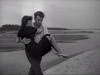 Movie still from “Obsession” (1943), directed by Luchino Visconti – A man and a woman walking on the beach; Wide shot, High angle