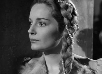 Movie still from “Othello” (1951), directed by Orson Welles – A black and white photo of a woman with a braid; Close Up shot, High angle