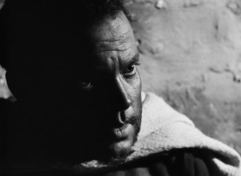 Movie still from “Othello” (1951), directed by Orson Welles – Black and white photograph of a man looking at the camera; Close Up shot, Low angle