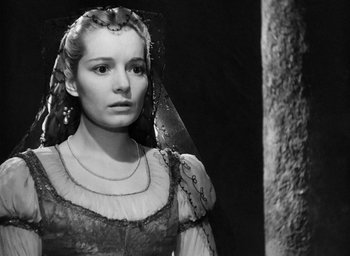 Movie still from “Othello” (1951), directed by Orson Welles – A black and white photo of a woman in a medieval dress; Close Up shot, Over the shoulder angle