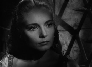 Movie still from “Othello” (1951), directed by Orson Welles – A black - and - white photo of a woman in a dress; Close Up shot, Over the shoulder angle
