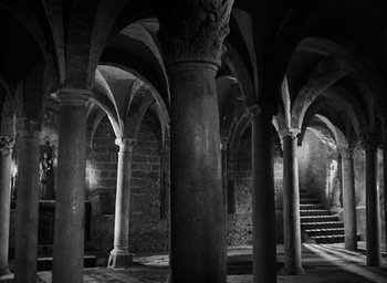 Movie still from “Othello” (1951), directed by Orson Welles – A black - and - white photo of some pillars in a building; Extreme Wide shot, High angle