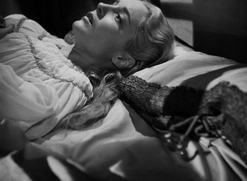 Movie still from “Othello” (1951), directed by Orson Welles – A black and white photo of a woman laying in a bed; Close Up shot, High angle