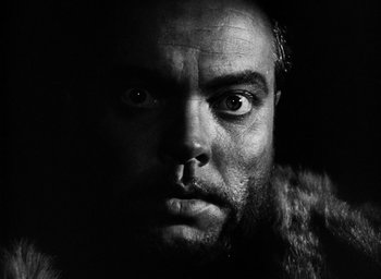 Movie still from “Othello” (1951), directed by Orson Welles – A person with a beard looking at the camera; Close Up shot, Low angle