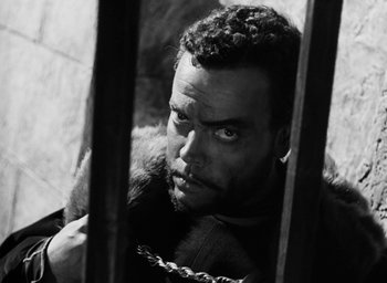 Movie still from “Othello” (1951), directed by Orson Welles – Black and white photograph of a man with a beard; Close Up shot, High angle