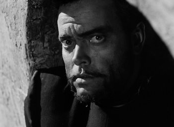 Movie still from “Othello” (1951), directed by Orson Welles – Black and white photograph of a man looking into the camera; Close Up shot, Low angle