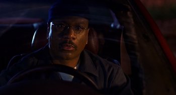 Movie still from “Out of Sight” (1998), directed by Steven Soderbergh – A man sitting in the driver's seat of a car at night; Close Up shot, Low angle