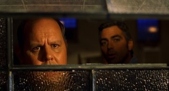 Movie still from “Out of Sight” (1998), directed by Steven Soderbergh – A man looking through a window at another man; Close Up shot, Low angle