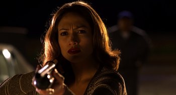 Movie still from “Out of Sight” (1998), directed by Steven Soderbergh – A woman is holding a gun in her hand; Close Up shot, Over the shoulder angle