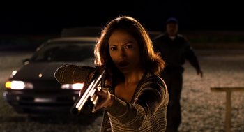 Movie still from “Out of Sight” (1998), directed by Steven Soderbergh – A woman holding a gun in her hand; Medium shot, Low angle