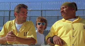 Movie still from “Out of Sight” (1998), directed by Steven Soderbergh – A group of men standing next to each other near barbed wire; Medium shot, Low angle