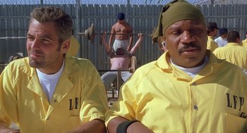 Movie still from “Out of Sight” (1998), directed by Steven Soderbergh – A group of men standing next to each other; Medium shot, Low angle